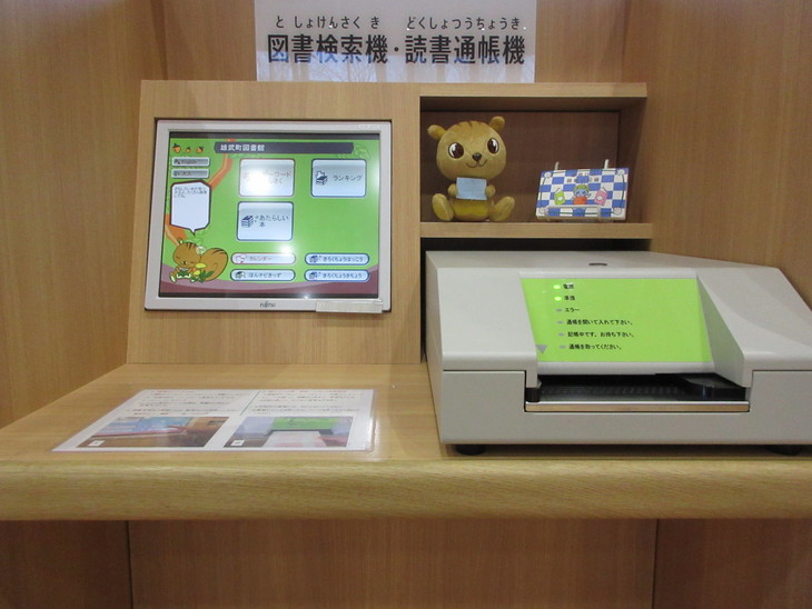図書館内に設置された図書館検索機と読書通帳機の写真