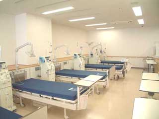 青いマットレスがひかれたベッドが5つ並んでいる、治療室の写真