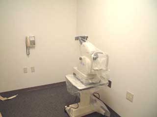 部屋の隅に、台に載った検査用の機械が置かれている部屋の写真