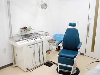 診察用の大きな椅子の横に、四角い大きな機械が置いてある写真