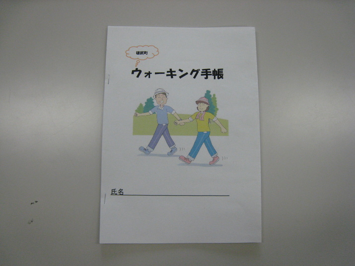 男性と女性が笑顔で歩いているイラストが描かれた、ウォーキング手帳の表紙