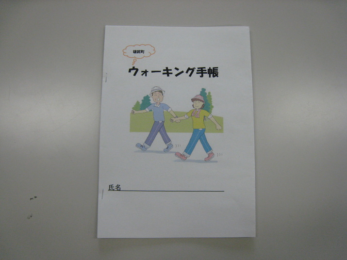 男性と女性が笑顔で歩いているイラストが描かれた、ウォーキング手帳の表紙