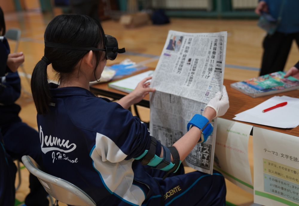 視野の変化を体験し新聞を読んでいる様子